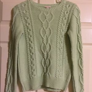 A mint green cable knit sweater